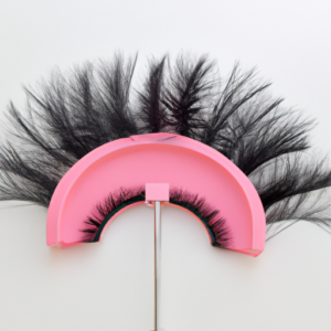 A pink eye makeup brush with a variety of false eyelashes on top.