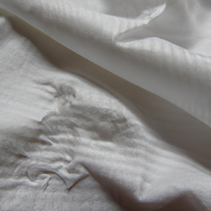 A close-up of a white cloth fabric with faint mascara smudges.