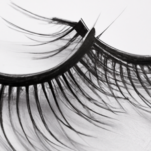A close-up of a pair of false eyelashes with long, thin strands.