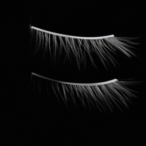 A pair of long eyelashes against a black background.