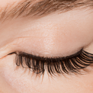 A close-up of a set of long thick eyelashes with a subtle hint of mascara.