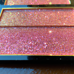 A bright pink eye shadow palette with a sparkly gold highlight.