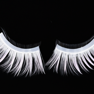 A close-up of a pair of mink false eyelashes against a black background.