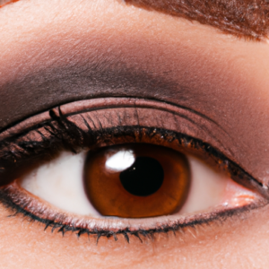 A close-up of a pair of almond-shaped eyes surrounded by a natural, earthy-toned palette of eyeliner and eyeshadow.