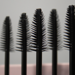 A close-up of a set of mascara brushes, arranged in a fan shape.