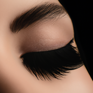 A close-up of lush, voluminous eyelashes against a black background.