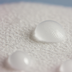 A close-up of a soft, white cotton pad with water droplets on it.